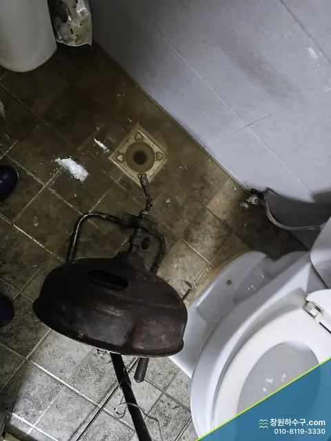 변기 옆 바닥배수구와 압축 뚫음 도구