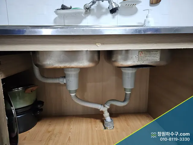 싱크대 하부장 속 배수 트랩과 주름관