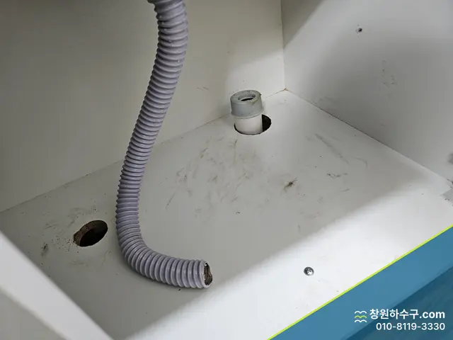 싱크대 하부장 바닥으로 이어진 배수 주름관