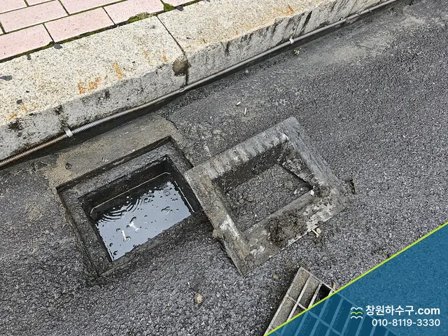 뚜껑을 연 도로변 빗물받이 두 칸