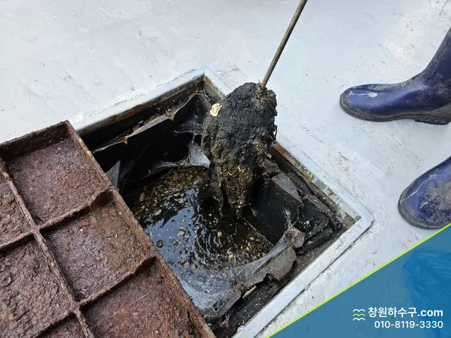 그리스트랩에서 기름 찌꺼기를 퍼내는 중