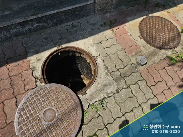 보도블록 위 열린 맨홀과 뚜껑