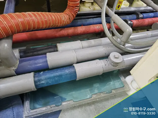 작업장 바닥을 지나는 여러 색 배관